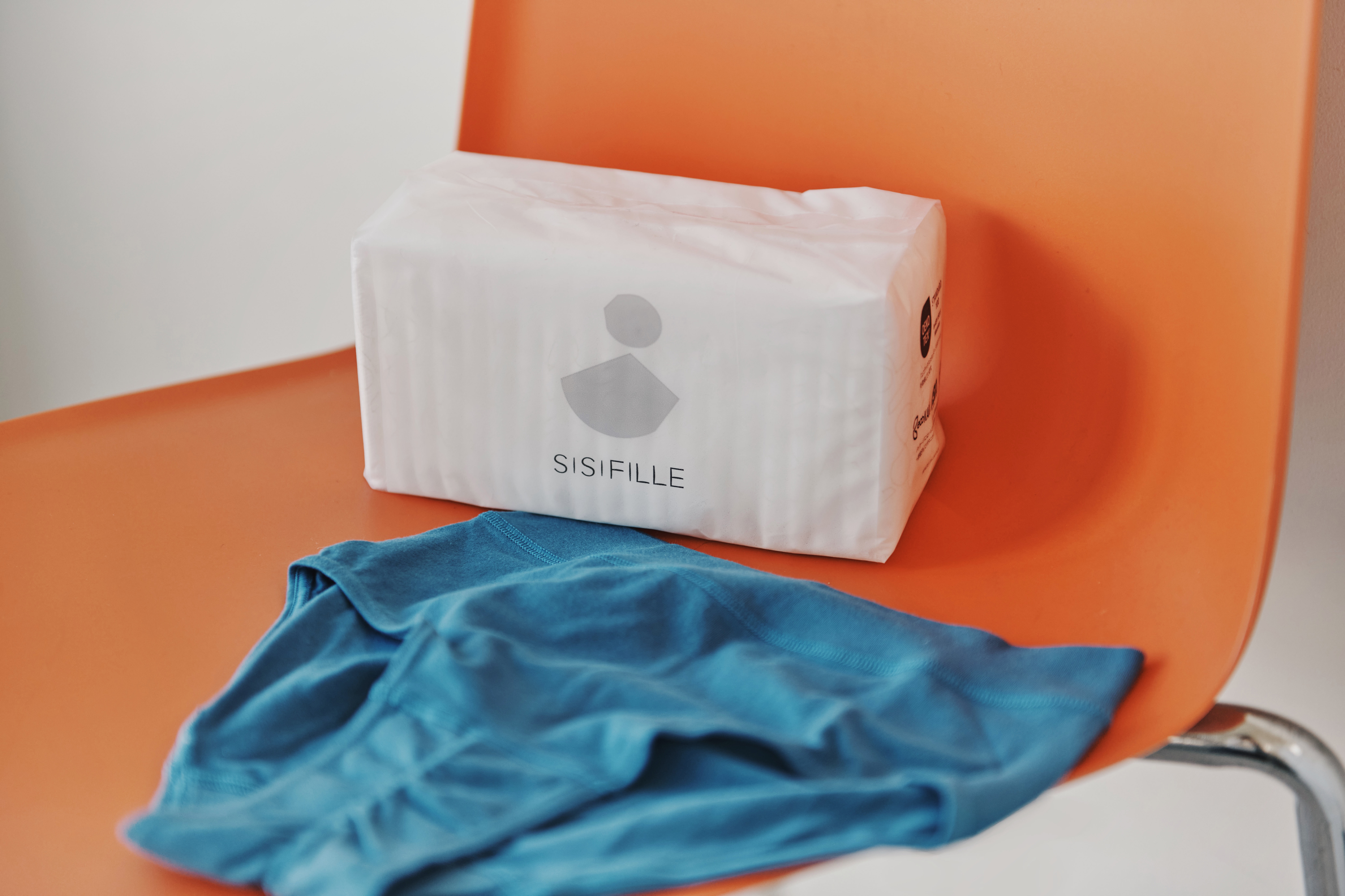 多い日用の羽ありタイプ。表面には、bioRe（ビオリ） PROJECT（※）から生まれた、タンザニア産のフェアトレード・オーガニックコットンを100%使用しています。吸収体には植物由来のパルプを使い、石油系の高分子吸収体を含まない「ノンポリマー」設計です。

日本では、生理用品の表面は白色であることが法律で定められています。SISIFILLEでは、塩素系よりも環境負荷が低く、肌にもやさしい「酸素系漂白」を採用しています。

製品全体でCO₂排出量の削減を目指し、パッケージにもこだわりを。
・フィルムの80％が植物由来原料。 サトウキビの残さ由来ポリエチレン（75%）＋卵殻（5%）
・印刷は、植物性ボタニカルインク（10%以上植物原料配合）を使用。
